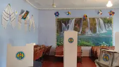 Празна избирателна секция с кабини за гласуване и урна